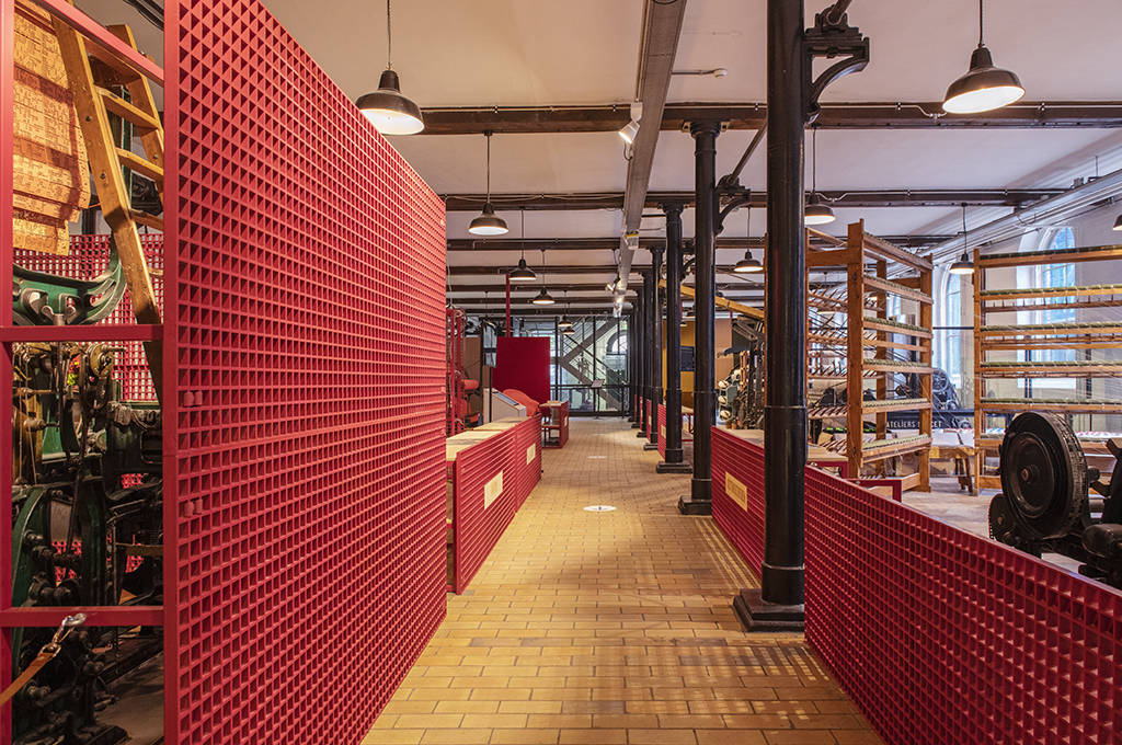 Tentoonstellingsontwerp Wollendekenfabriek met door en door gekleurde roosters op de schotten.